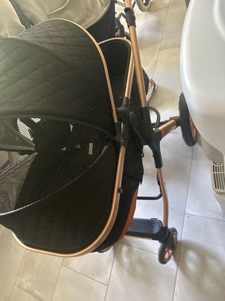 Cochecito de bebé negro y dorado