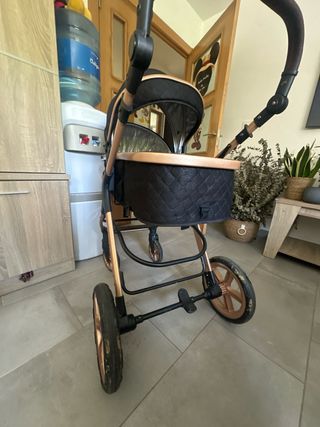 Cochecito de bebé negro y dorado
