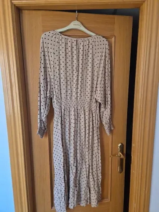 Vestido beige con lunares negros.