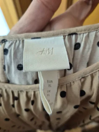 Vestido beige con lunares negros.