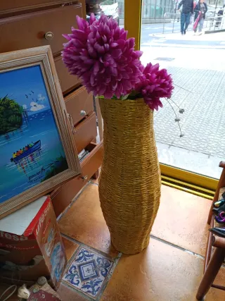 Jarrón de mimbre con flores rosas