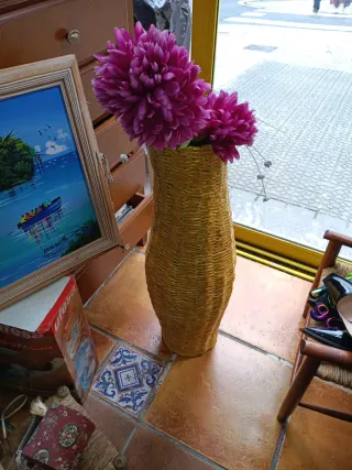 Jarrón de mimbre con flores rosas