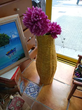 Jarrón de mimbre con flores rosas