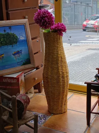 Jarrón de mimbre con flores rosas
