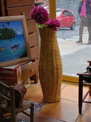 Jarrón de mimbre con flores rosas