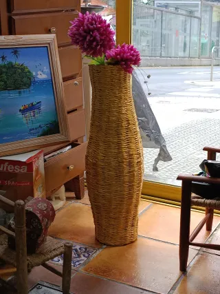 Jarrón de mimbre con flores rosas