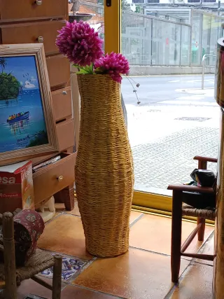 Jarrón de mimbre con flores rosas