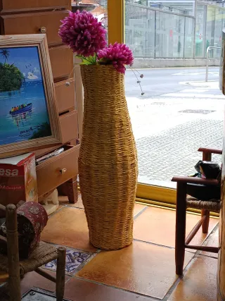 Jarrón de mimbre con flores rosas