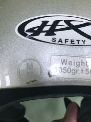 Casco de moto plateado con visor