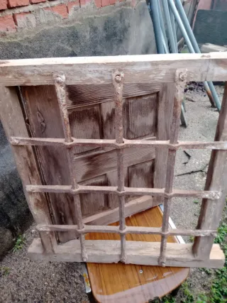 Ventana madera vieja con reja forja
