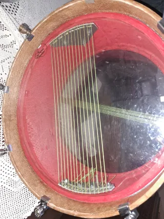 Tambor con cuerdas y sonajero