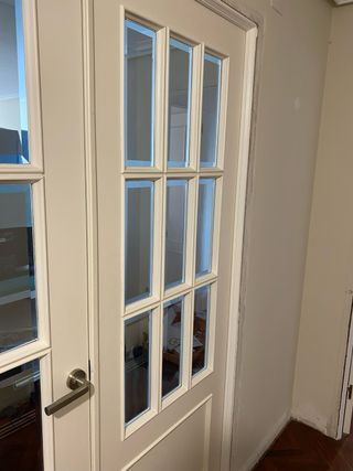 Puerta lacada doble con cristal blanca molduras.