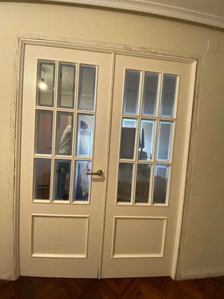Puerta lacada doble con cristal blanca molduras.
