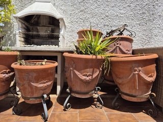 Macetas de barro con sus respectivos pies de forja