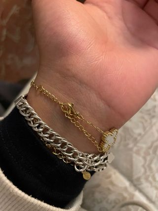Pulsera dorada con tréboles blancos