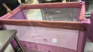 Cuna de viaje rosa con puntos blancos
