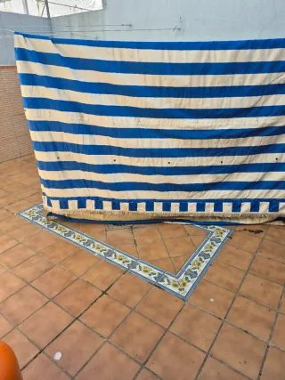 Toldo azul y blanco con flecos