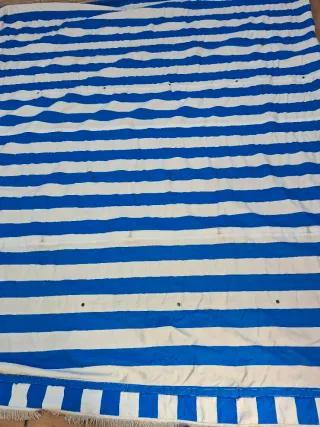 Toldo azul y blanco con flecos