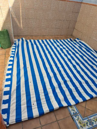 Toldo azul y blanco con flecos