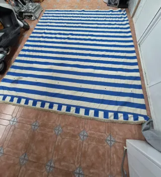 Toldo azul y blanco con flecos