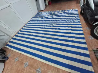 Toldo azul y blanco con flecos
