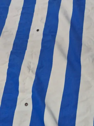 Toldo azul y blanco con flecos