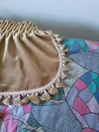 Volantes de terciopelo beige con flecos.