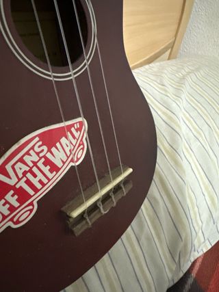 Ukelele color burdeos con pegatina Vans