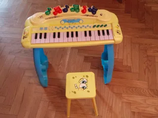 Piano de juguete amarillo con silla