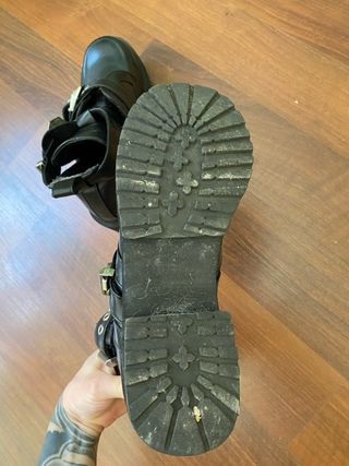 Botines de cuero negro con hebillas plateadas.