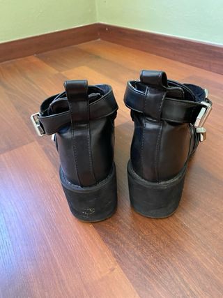 Botines de cuero negro con hebillas plateadas.