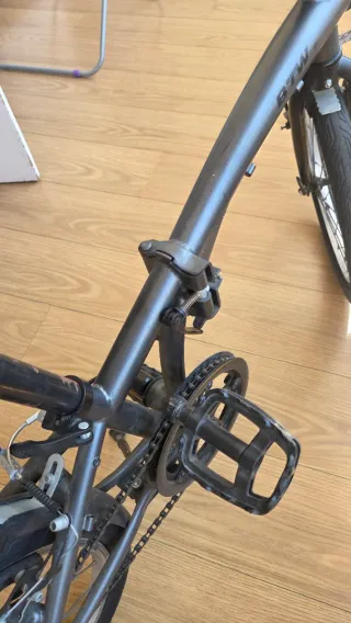 Bicicleta plegable Btwin gris oscuro con candado.