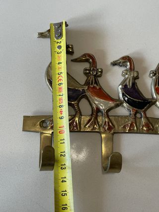 Percha de metal vintage con patos policromados.