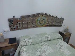 Cartel antiguo de madera adaptado a cabecero cama