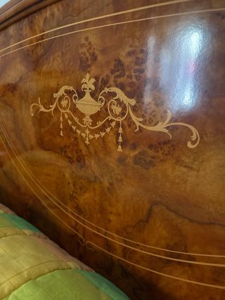 Cama de madera con colcha multicolor y somier