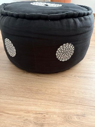 Puff redondo negro con diseño floral