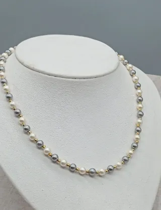 Collar de perlas grises y blancas .