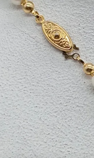 Collar de perlas grises y blancas .