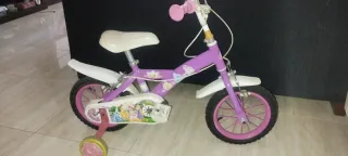 Bicicleta infantil morada con ruedas de apoyo