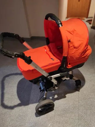 Carrito de bebé naranja. Marca Concord.