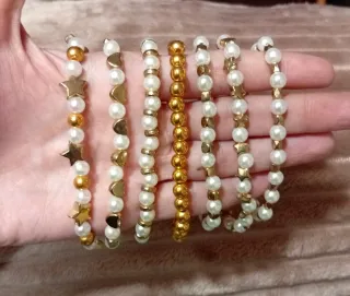 Diferentes pulseras con perlas y detalles dorados