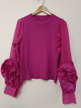 Blusa manga organza volantes fucsia formando flor.
