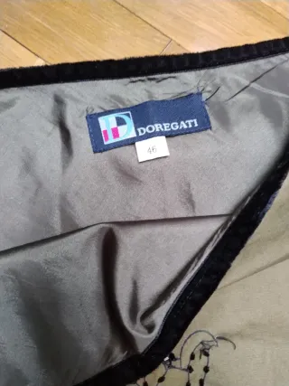 Falda verde con pájaro y flor bordados.