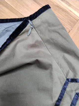 Falda verde con pájaro y flor bordados.