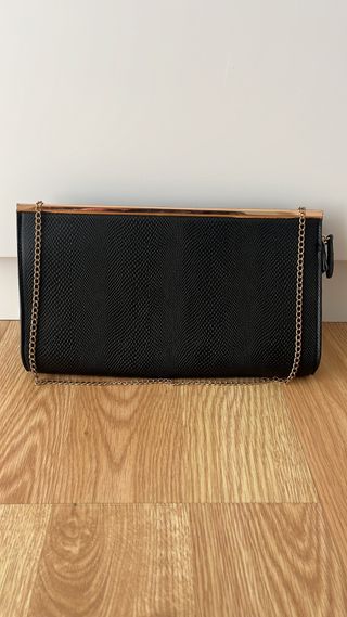 Bolso de mano negro con cadena dorada,