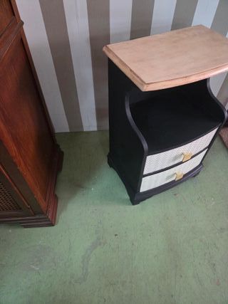 Mesilla de noche negra con detalles dorados.