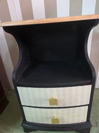 Mesilla de noche negra con detalles dorados.