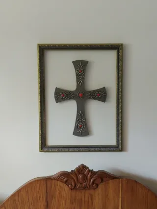 Cruz decorativa antigua con adornos rojos