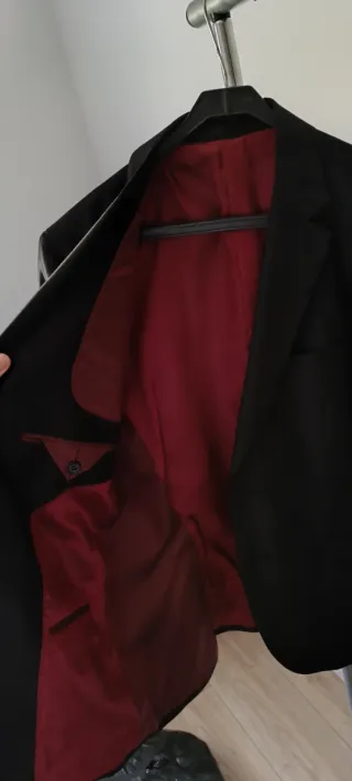 Traje de diseño negro con forro rojo