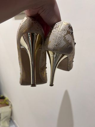 Zapatos dorados stiletto con tachuelas